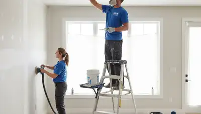 Painter repairing drywall cracks and water damage in a Madison WI home interior wall restoration project